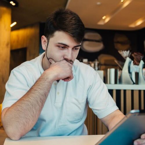 Restaurant manager reviewing email marketing results on a tablet, analysing why email marketing campaigns are failing to engage guests